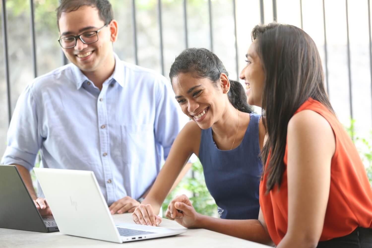 Zapulse team members collaborating around a laptop